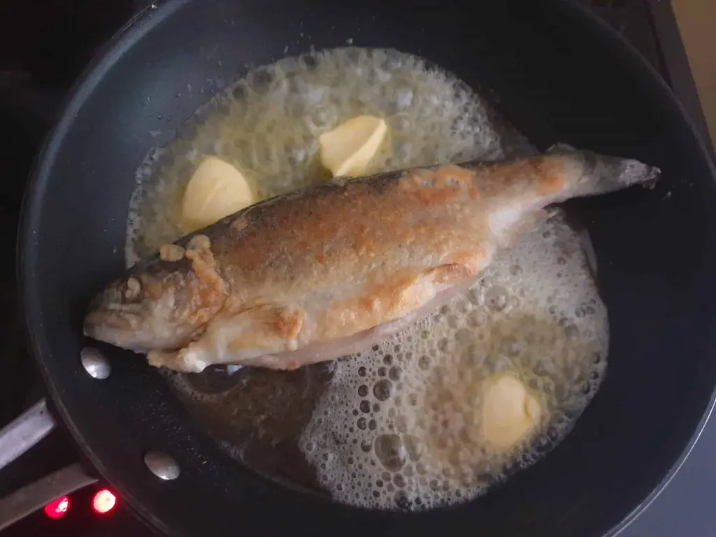 Frying the trout almondine in plenty of butter
