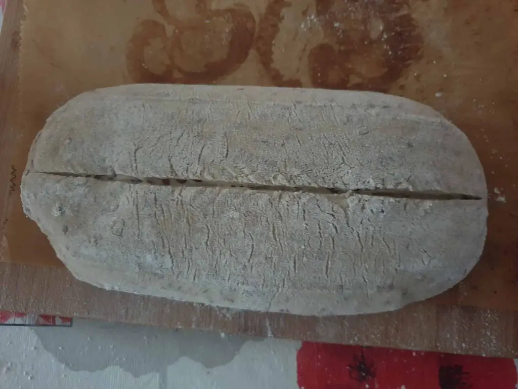 Scoring the dough for mixed bread with seeds