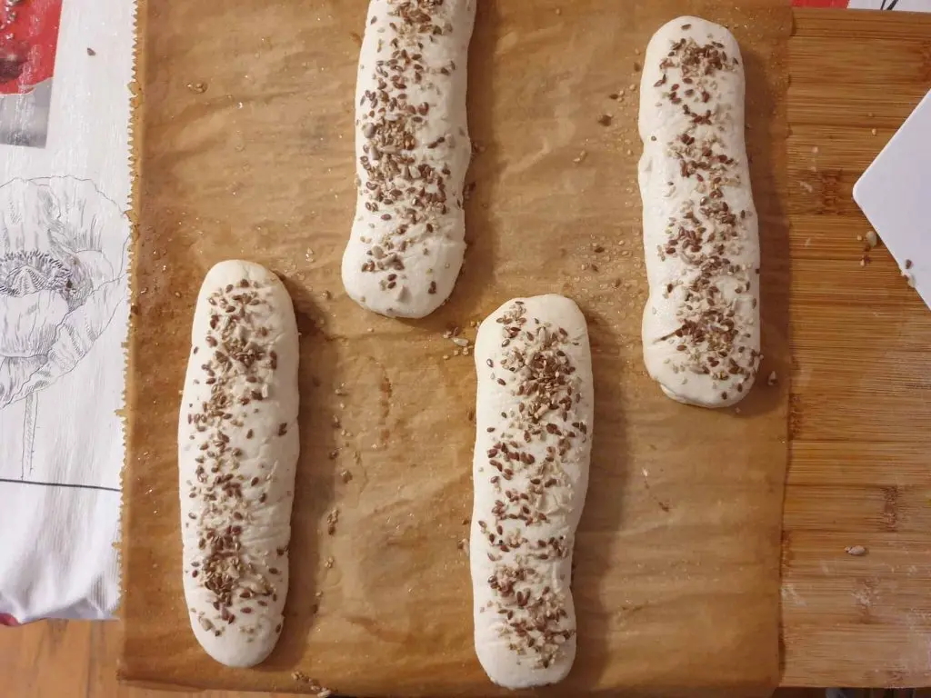 Sprinkling the breadsticks with seeds