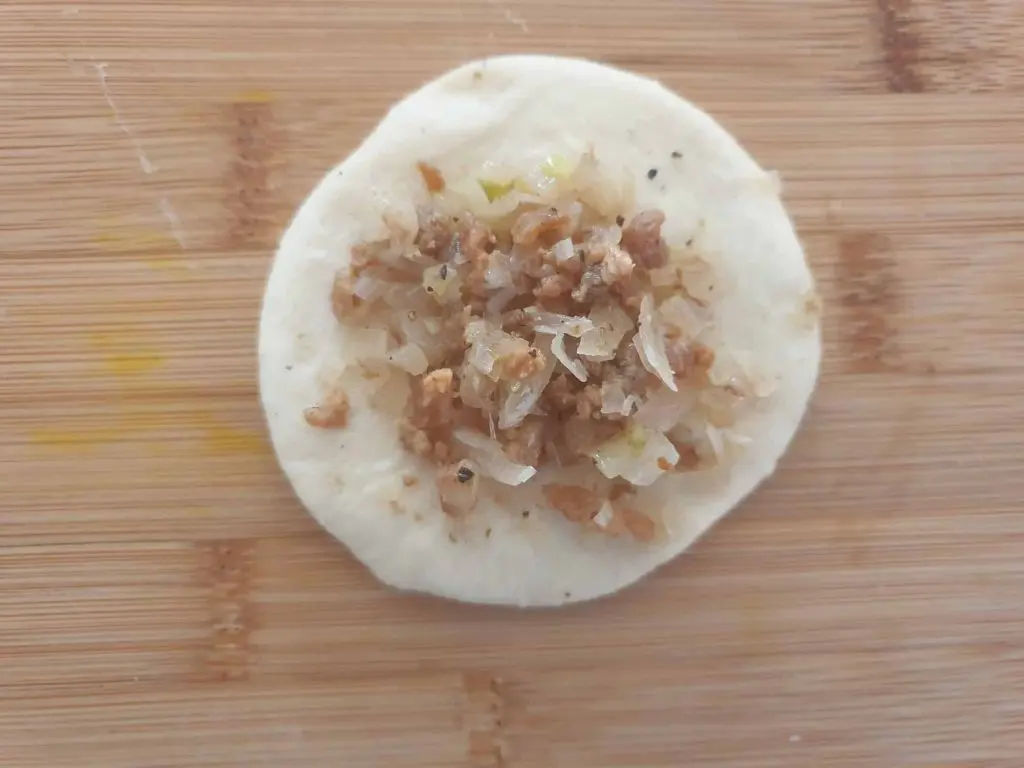 Placing the filling in the center of the dough circle