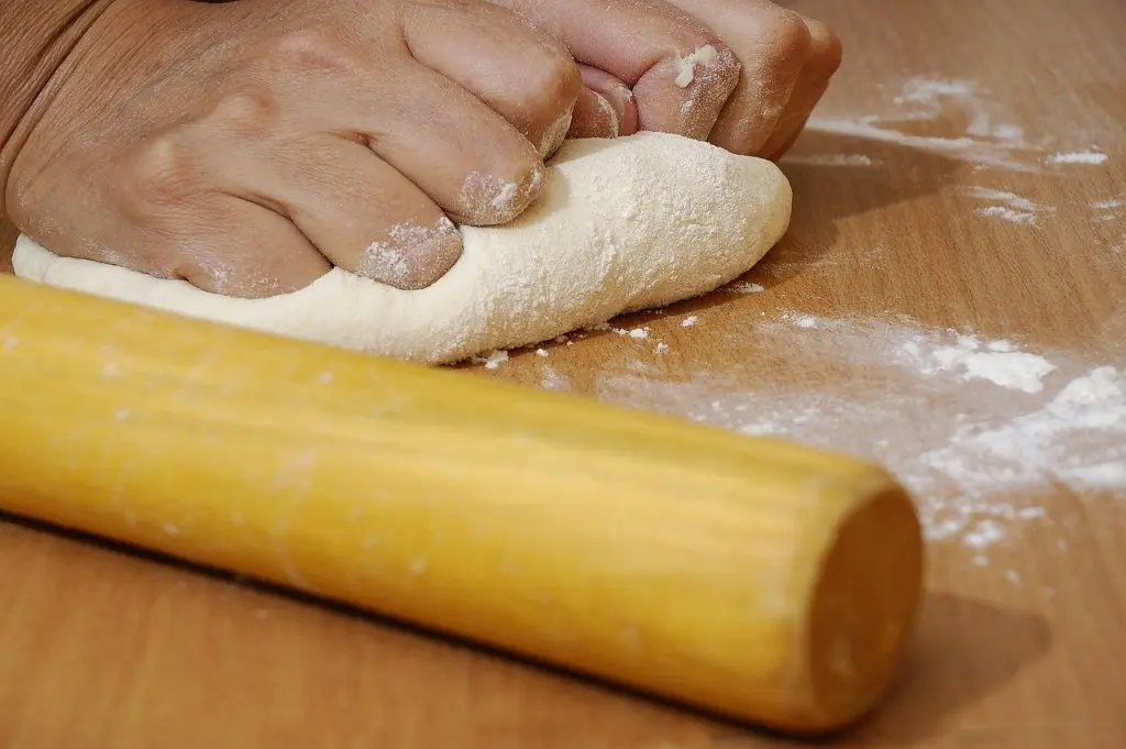 Kneading bread dough to create gluten emulsifier bonds